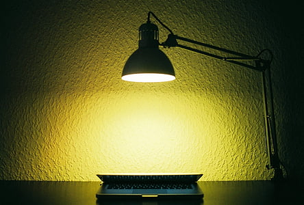 black laptop under turned on lamp thumbnail