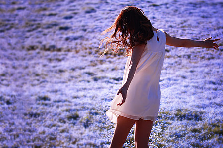 depth of field photography of woman standing on field of purple flowers thumbnail