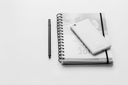 white Xiaomi Android smartphone on top of spiral notebook thumbnail