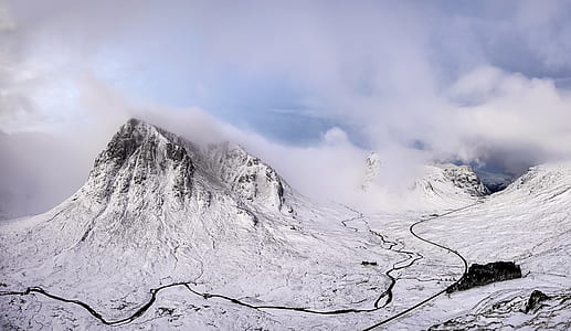 snow-covered mountain surrounded by clouds at daytime thumbnail