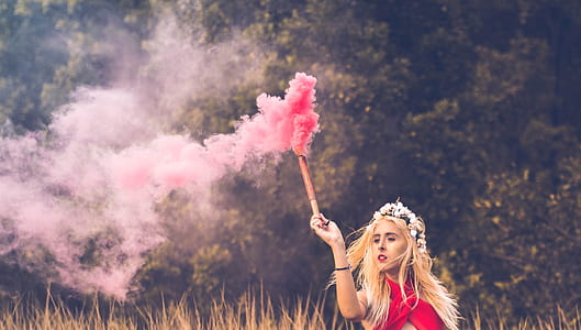 woman in red top holding brown stick thumbnail