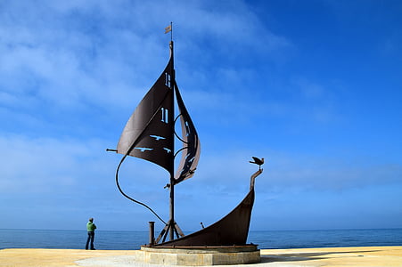 person standing near sailboat statue thumbnail