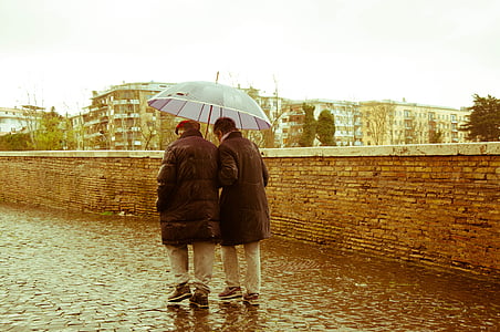 two person holding umbrella walking under the rain thumbnail