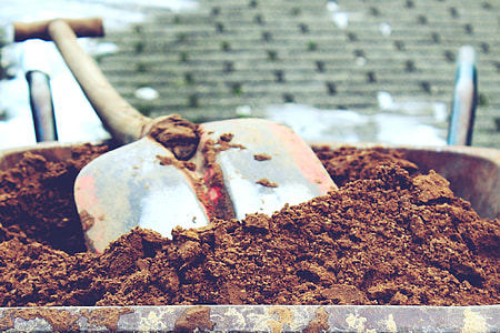 close up photo of soil in wheelbarrow with shovel thumbnail