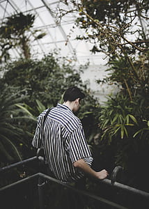 man wearing black and white striped shirt sitting on gray metal rails thumbnail