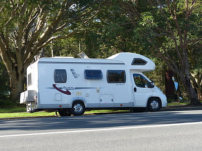 white class-B motor home beside tree thumbnail