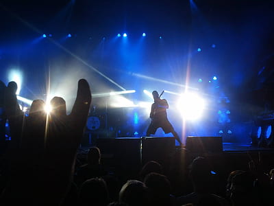 man holding guitar while standing on stage thumbnail