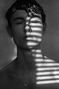 grayscale photo of man leaning wall thumbnail
