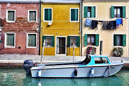 gray boat in front of buildings thumbnail