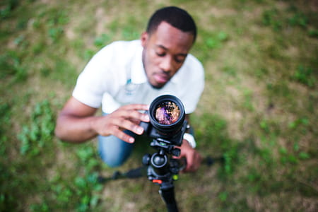 selective focus photography of man sitting installing DSLR camera thumbnail