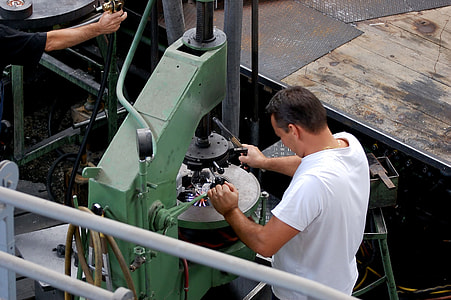 man in white T-shirt using tire changer machine thumbnail