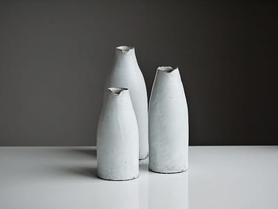 three white ceramic flower vases on white surface thumbnail