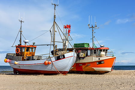 white and orange ship on seashore thumbnail