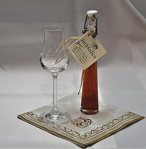 clear glass decanter and wine glass on top of fabric mat thumbnail