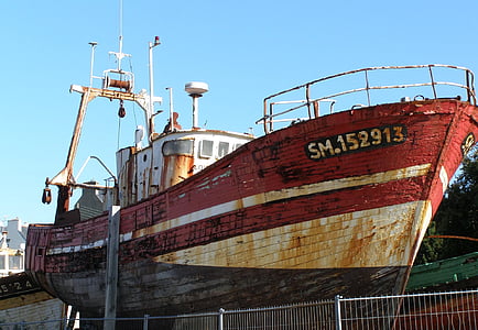 rusty old ship docked near a dock thumbnail