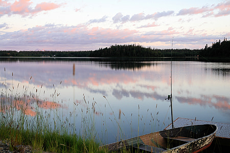 photography of canoe near calm body of water under white sky thumbnail