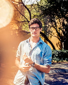 Man Wearing Black Eyeglasses and Blue Denim Button-up Elbow-sleeved Shirt thumbnail