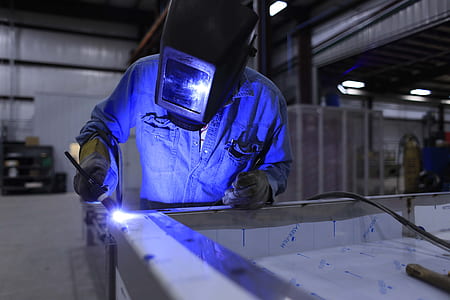 welder wearing helmet and blue uniform thumbnail