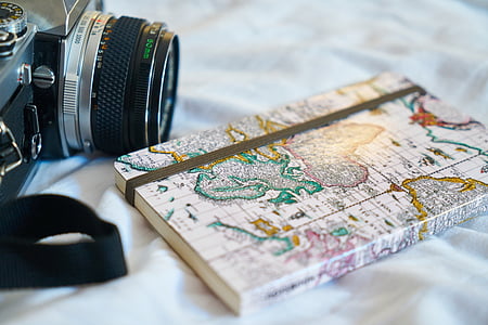 closeup photo of book on white textile beside the camera thumbnail