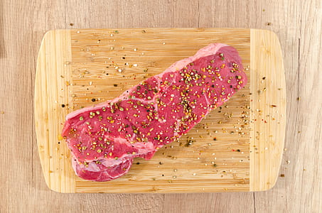 seasoned slice of meat on brown chopping board thumbnail