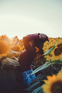 photo of woman holding her hair surrounding by sunflowers thumbnail