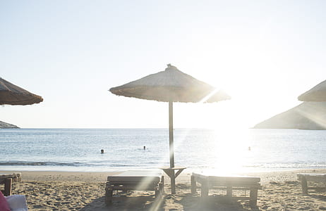 photo of beach lounge chairs in front of body of water during daytime thumbnail