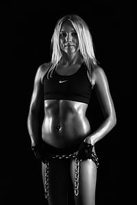 grayscale photo of woman in black Nike sports bra thumbnail