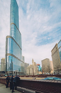 three policeman leaning on railing facing buildings under blue sky thumbnail