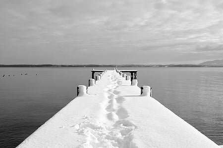 dock covered by snow under white cloudy sky thumbnail