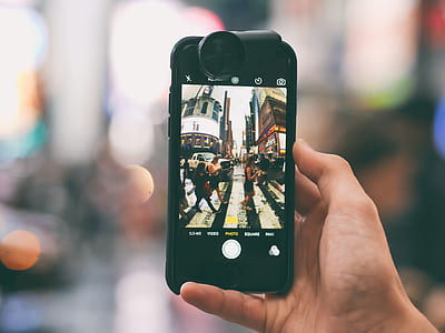 person holding iPhone showing people walking pedestrian lane thumbnail