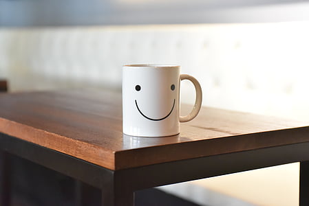 white ceramic mug on brown wooden table thumbnail