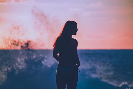 woman standing near ocean waves during day time thumbnail