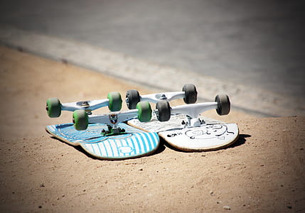 blue and white skateboard on brown dirt during daytime thumbnail
