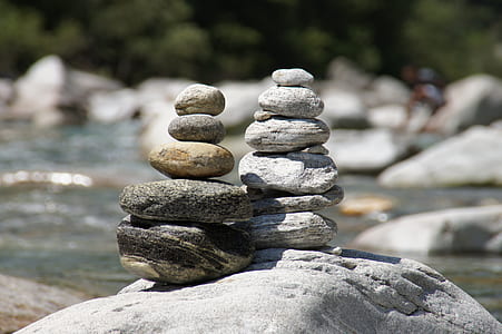 smooth gray and black stones near body of water at daytime thumbnail