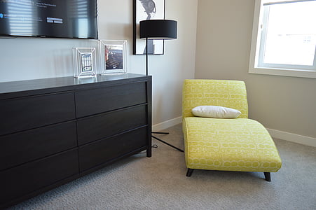 yellow chaise lounge with white pillow on top beside black floor lamp near window thumbnail