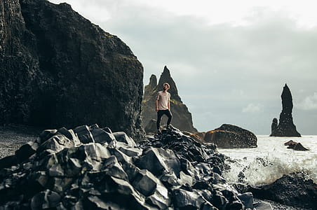 A young caucasian hiker on volcanic rocks by the sea thumbnail