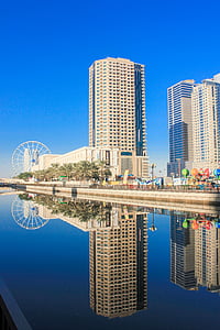 concrete high rise building near calm water thumbnail