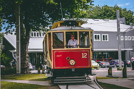 Man Riding on Red and Beige Train thumbnail