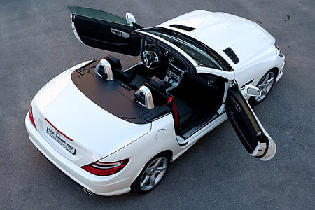 white BMW coupe with 2 doors open on gray pavement thumbnail