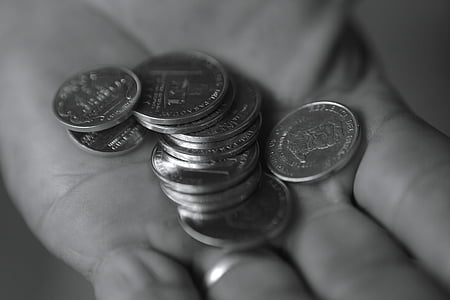 person holding pile of coins thumbnail