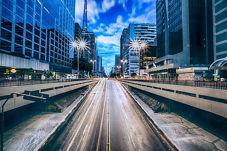 grey concrete road between high rise buildings thumbnail