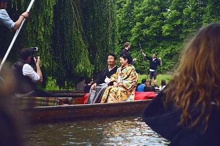 Man and Woman Sitting on Brown Canoe thumbnail