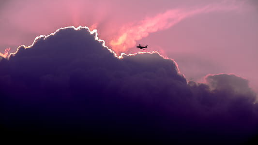 passenger plane passing through clouds during sunset thumbnail