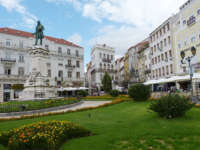 green statue of man in front of buildings thumbnail