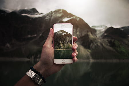 person taking photo of brown mountain thumbnail