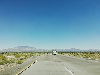 white vehicle on gray concrete top road near green plants under blue sky during daytime thumbnail
