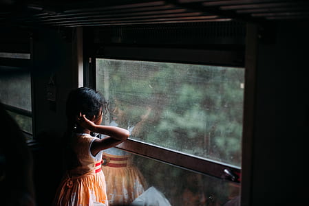 girl in white and orange dress beside window during daytime thumbnail