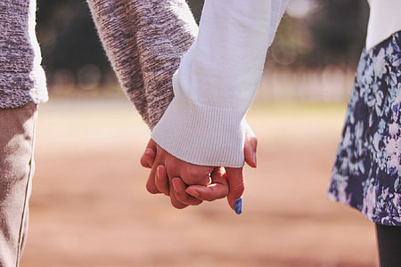 man and woman holding hands while walking thumbnail