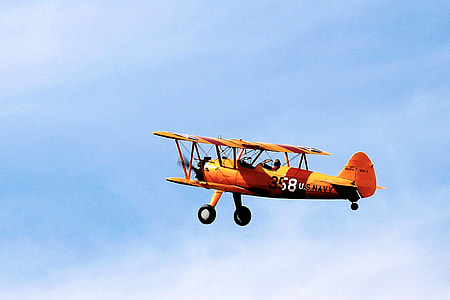 orange U.S Navy biplane in flight thumbnail
