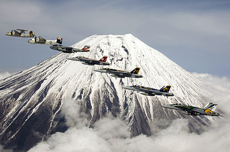 several planes flying over white and gray mountain thumbnail